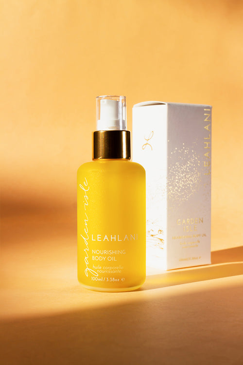 Garden Isle - Huile Corporelle Nourrissante Lehalani de 100 ml dans un flacon pompe en verre transparent de couleur jaune miel.