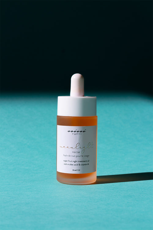 Huile de nuit Moonlight de chez Nini organics dans un lfacon en verre transparent de 30 ml qui laisse apparaître la douce couleur orangé
